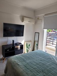 a bedroom with a bed and a flat screen tv at Amplio Monoambiente con buena ubicación in Paraná