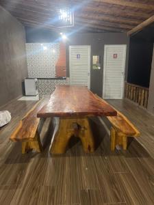 una mesa de madera con 2 bancos en una habitación en Espaço Diniz, en Santa Luzia