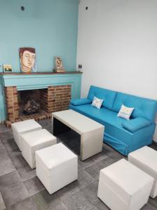ein Wohnzimmer mit einem blauen Sofa und einem Kamin in der Unterkunft Hostel Dakini Lomas in Partido Lomas de Zamora