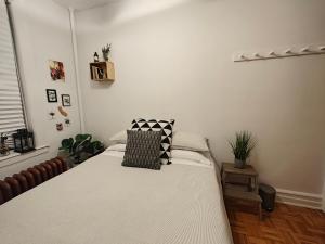 a bedroom with a white bed with a pillow on it at Two bedroom excellent location in Queens