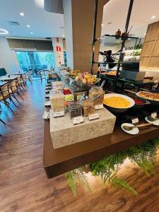 una línea de buffet con muchos tipos diferentes de comida en Transamerica Belo Horizonte Lourdes, en Belo Horizonte