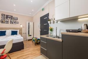 a bedroom with a bed and a kitchen with a sink at Apartments Neo in Rijeka