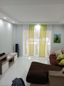 ein Wohnzimmer mit gelben Vorhängen und einer Couch in der Unterkunft LA RAZÓN DE MI SER in Chiclana de la Frontera