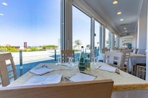 una sala da pranzo con tavolo e una grande finestra di Hotel Bellevue a Cattolica