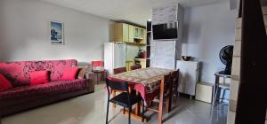 a living room with a table and a red couch at Residencial Hannah - Casa 6 - Porto Belo SC - Bairro Perequê in Porto Belo