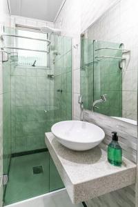 a bathroom with a sink and a glass shower at Casa Água Branca, Contagem - prox.arena MRV in Contagem