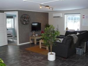 a living room with a couch and a tv at "Huset Alcamaro" in Haugland