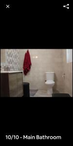 een badkamer met een toilet en een rode handdoek bij Eros in St Paul's Bay