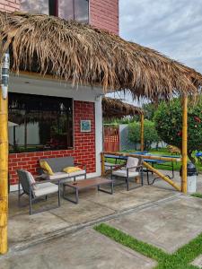 瓦拉爾的住宿－Disfruta de paz y armonía en huaral，一个带桌椅的庭院和一个草屋顶。