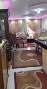 a kitchen and living room with a couch and a table at شقة فندقية in Qaryat ash Shamālī