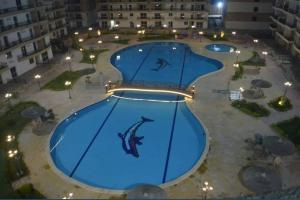 an overhead view of a large swimming pool at night at شقة فندقية in Qaryat ash Shamālī