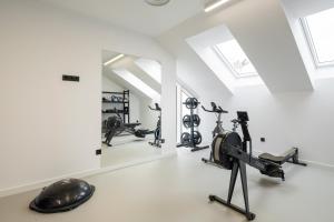 a gym with treadmills and exercise equipment and a mirror at Sercotel EsteOeste in Lugo