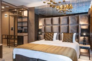 a bedroom with a large bed with a large headboard at Art Suites Luxury Hotel in Kraków