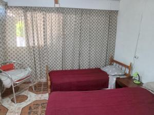 a bedroom with two beds and a table and a window at LAPOSTa555 in Piriápolis