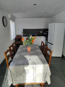 a dining room with a table with chairs and a refrigerator at Villa collections appartement trois chambres a partager ou pas in Vergèze