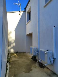 a white building with two utility boxes on the side of it at Villa collections appartement trois chambres a partager ou pas in Vergèze