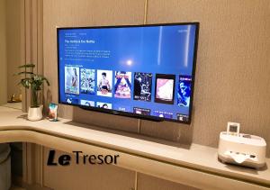 a flat screen tv sitting on top of a counter at Le Tresor Benson Apartment at Supermal Pakuwon in Surabaya