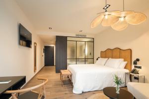 1 dormitorio con 1 cama blanca y sala de estar en Sercotel EsteOeste, en Lugo