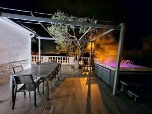 a wooden table and chairs on a deck at night at Villa vue mer, terrasse et spa in Nice