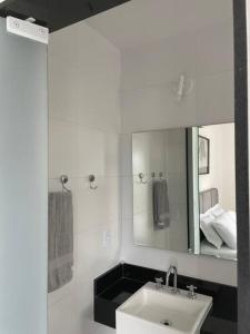 帕蒂杜阿爾費里斯的住宿－Mordô da serra casa inteira acomoda até 30 pessoas，白色的浴室设有水槽和镜子