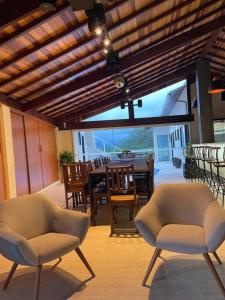 帕蒂杜阿爾費里斯的住宿－Mordô da serra casa inteira acomoda até 30 pessoas，一个带两把椅子和一张桌子的庭院和一间餐厅