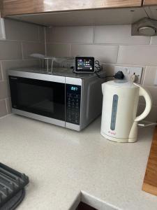a microwave sitting on a kitchen counter next to a blender at Ulker in Bristol