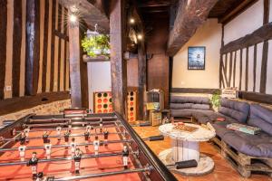 a living room with a foosball table and a couch at Gites - Domaine de Geffosse in Pont-lʼÉvêque