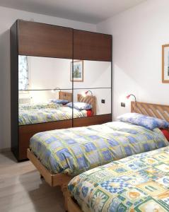 een slaapkamer met 2 bedden en een grote spiegel bij Casa Venezia e Riviera in Mirano
