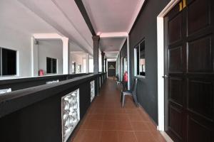 um corredor com paredes pretas e uma porta castanha em Langkawi Tok Jah Guest House em Pantai Cenang