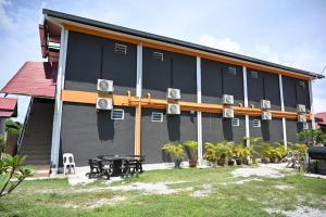 a building with a picnic table in front of it at Langkawi Tok Jah Guest House in Pantai Cenang