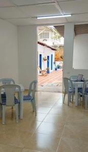 a dining room with tables and chairs and a patio at La Marina Hostal in Ríohacha