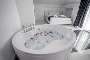 a white bath tub in a room with a bed at Delago in Ohrid