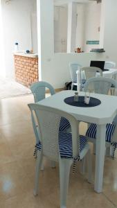 a white table and chairs in a room at La Marina Hostal in Ríohacha