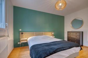 a bedroom with a green wall and a bed at l'Éclat Contemporain in Seyssinet-Pariset