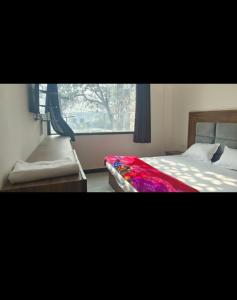 a bedroom with a bed sitting next to a window at M.D. Grand Hotel N Resort in Agra