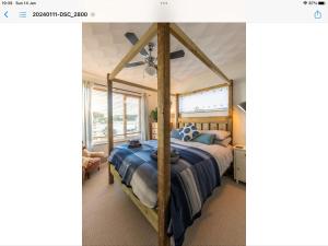 a bedroom with a canopy bed with a blue comforter at Lovely 1-Bed Apartment with stunning sea views in Looe