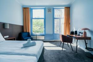Habitación de hotel con cama, escritorio y escritorio. en Hotel Omega, en Ámsterdam