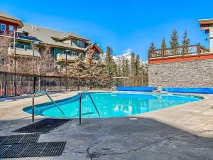 ein Pool in einem Garten mit einem Zaun in der Unterkunft Canmore Mountain view loft apartment heated outdoor pool in Canmore