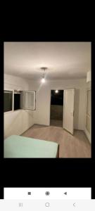 an empty room with a bed and a refrigerator at Vlado apartments in Podgorica