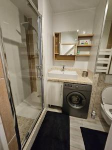 a small bathroom with a washing machine and a sink at Le 301 Vercingétorix - Proche Paris & Disney in Champigny-sur-Marne