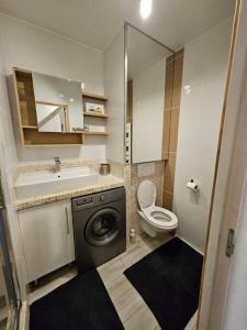 a bathroom with a toilet and a sink and a washing machine at Le 301 Vercingétorix - Proche Paris & Disney in Champigny-sur-Marne