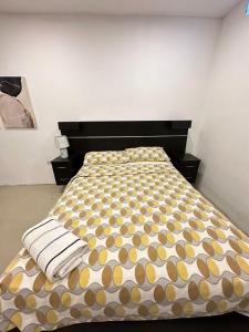 a bedroom with a bed with a brown and yellow bedspread at Suite Bosque de la Alborada B in Guayaquil