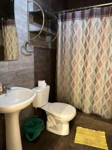 a bathroom with a white toilet and a sink at Suite Bosque de la Alborada B in Guayaquil
