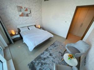 een slaapkamer met een bed, een stoel en een tafel bij Nearest to the Airport l Beautiful 1 BR Apt in Abu Dhabi