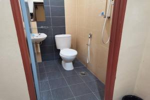 a bathroom with a toilet and a sink at Langkawi Tok Jah Guest House in Pantai Cenang