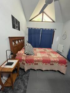 a bedroom with a bed and a table and a window at Dpto Santa Rosa in Santa Rosa de Calamuchita