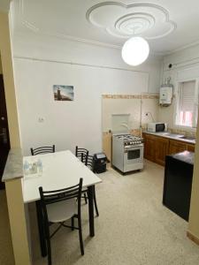 kuchnia ze stołem i krzesłami w pokoju w obiekcie Hostel Apart w mieście Dar el Beïda