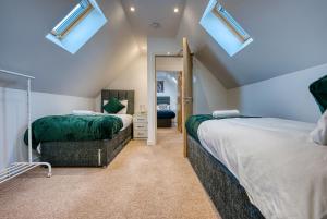 a attic bedroom with two beds and skylights at Large 5 Bed House near NEC, BHX AIRPORT, HS2, Private Parking in Birmingham