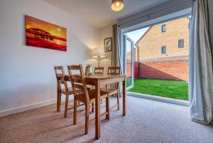 a dining room with a table and chairs and a large window at Large 5 Bed House near NEC, BHX AIRPORT, HS2, Private Parking in Birmingham