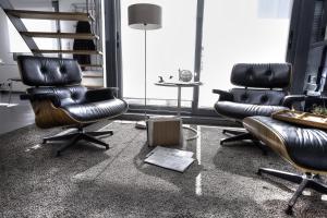 twee stoelen en een tafel in een kamer met een trap bij Beautiful Loft 130m2 Sun and free parking in La Garenne-Colombes